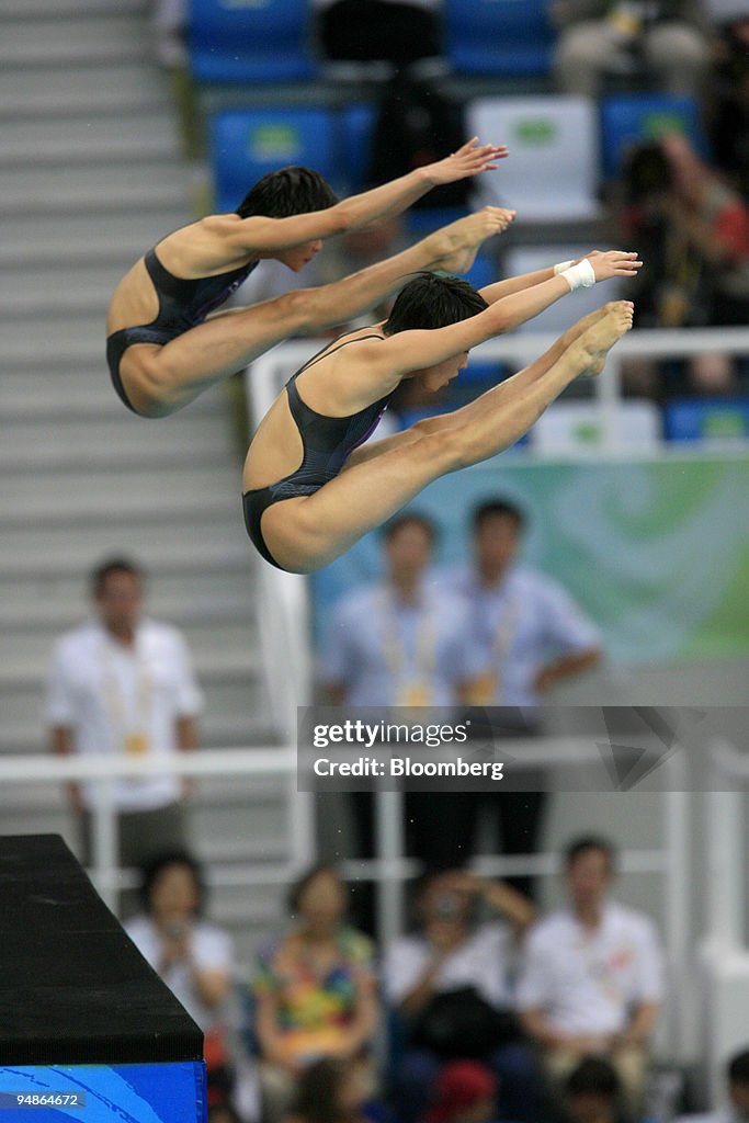 Wang Xin, left, and Chen Ruolin of China, hold a pike positi