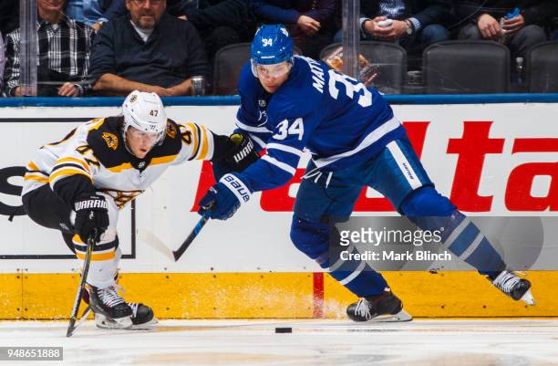 Auston Matthews of the Toronto Maple Leafs battles for the puck with Torey Krug of the Boston Bruins in Game Three of the Eastern Conference First...