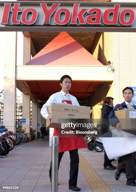 Employees carry boxes out of an Ito-Yokado department store in Tokyo on Tuesday, November 30, 2004. Japanese factory production slumped, households...