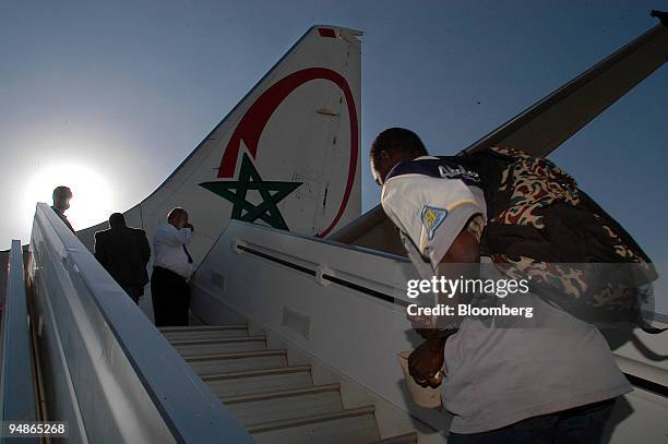 Immigrants are seen boarding a Mali-bound Royal Air Maroc plane, the first repatriation flight issued by the Moroccan government, at the Oujda-Angad...