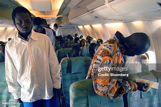 Immigrants are seen boarding a Mali-bound Royal Air Maroc plane, the first repatriation flight issued by the Moroccan government, at the Oujda-Angad...