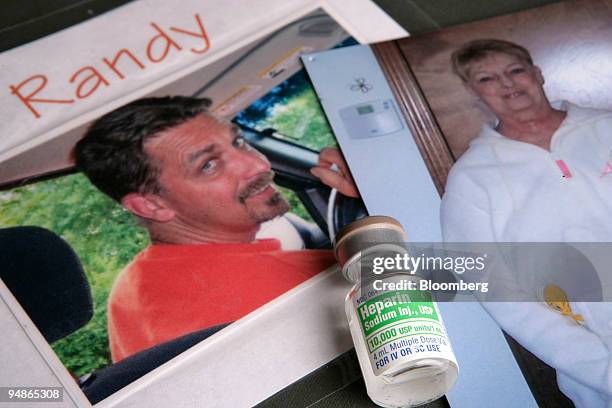 Leftover vial from the lot of contaminated Heparin sold by Baxter International Inc. Is arranged with photographs of deceased Bonnie Hubley and her...