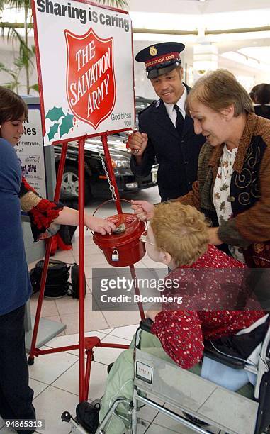 Salvation Army bell ringer, Rickie Armour, collects donations in the kettle on the first day of collections during the holiday season at the Quaker...
