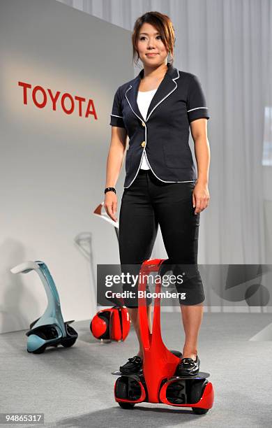 Woman demonstrates Toyota Motor Corp.'s newly developed personal transport assistance robot "Winglet" type M in Tokyo, Japan, on Friday, Aug. 1,...