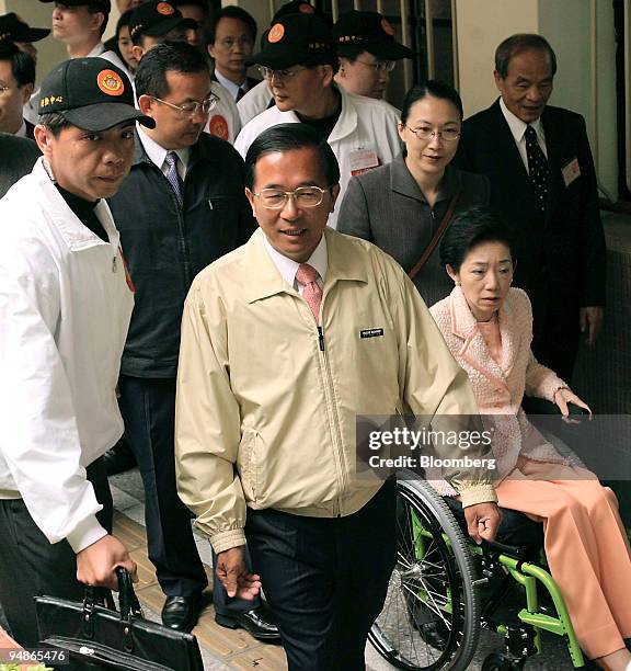 Taiwan's President Chen Shui-bian walks with his wheelchair-bound wife, Wu Shu-chen, and security gaurds after voting in Taipei early Saturday, March...