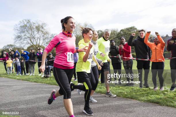 enthusiastic family runners running in charity run at park - race spectator stock pictures, royalty-free photos & images