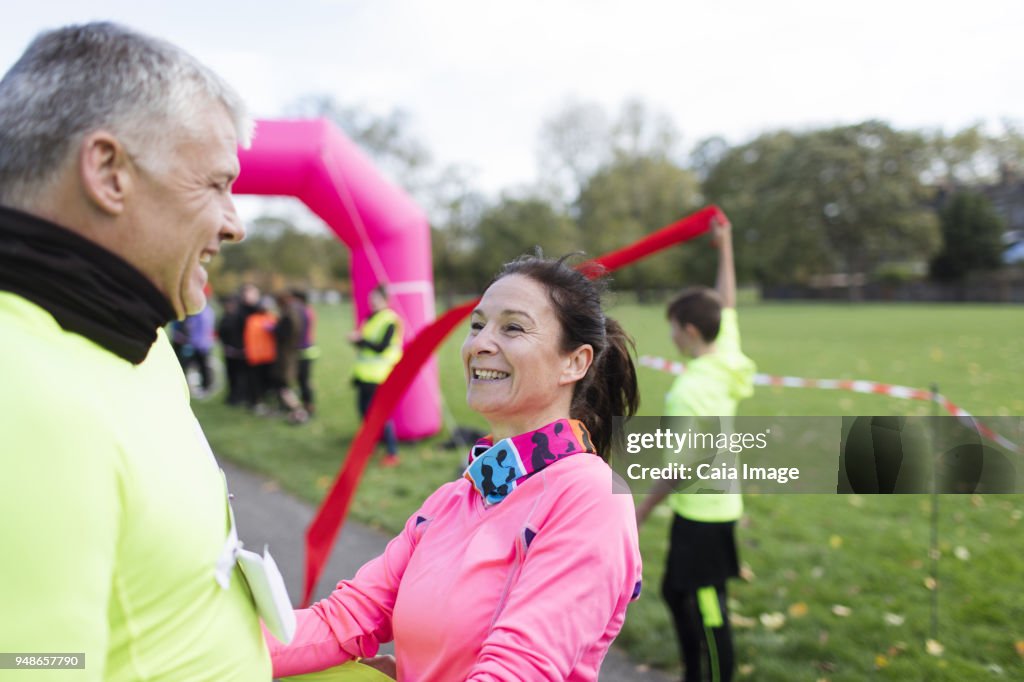 Happy runners crossing finish line at charity run in park