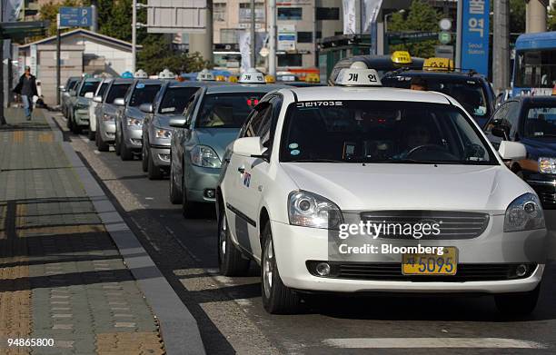 Taxi drivers form a line as they await customers at a taxi stand in Seoul, South Korea, on Monday, Oct. 27, 2008. From writers to builders to chief...