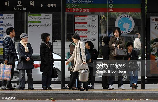 People wait at a bus station in Seoul, South Korea, on Monday, Oct. 27, 2008. From writers to builders to chief executives, the won's 28 percent...