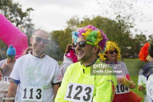 playful runner in wig at charity run in park - paint race stock pictures, royalty-free photos & images