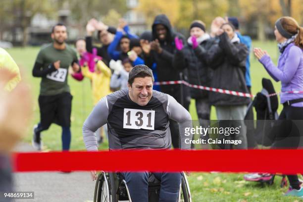 Determined man in wheelchair nearing charity race finish line in park