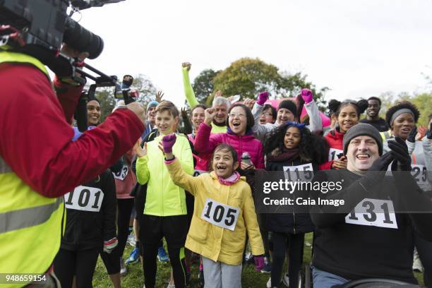 cameraman filming cheering crowd of runners at charity race - race 8 stock pictures, royalty-free photos & images