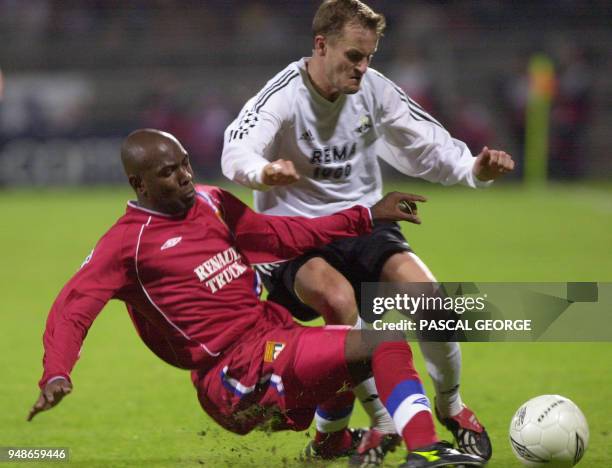 Le défenseur lyonnais Claudio Caçapa tente de tacler le norvégien Harald Martin Brattbakk, le 25 Septembre 2002 au stade Gerland à Lyon, lors du...