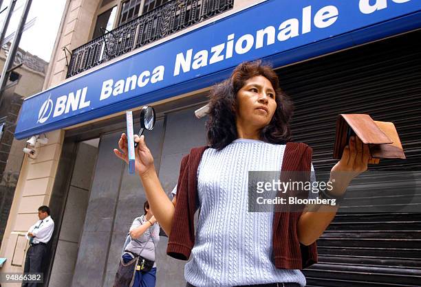 Woman sells magnifying glasses and wallets in front of the headquarters of Banca Nazionale del Lavoro in Buenos Aires, Argentina, March 18, 2004...