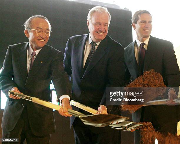Toyota President Katsuaki Watanabe, left, and Canadian Prime Minister Paul Martin, center, and Ontario premier Dalton McGuinty wield their golden...