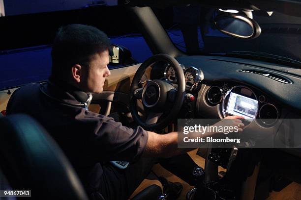 Christian Steurer, a product manager with E.E.P.D., examines an computer system installed into a Mini Cooper at the 2005 Computex Information and...