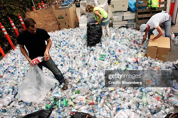 Marcus Eriksen, Anna Cummins, and Joel Paschal collect plastic bottles at a recycling center for a boat they are building made from the recycled...