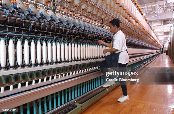 Thirty-year-employee Patricia Davis operates a weaving machine called a link spinner at the Cone Mills Corp. Plant in Greensboro, North Carolina on...