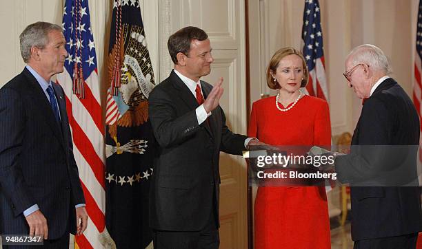 John Roberts, second from left, is sworn in as the Chief Justice of the U.S. Supreme Court by Justice John Paul Stevens, right, during a ceremony in...