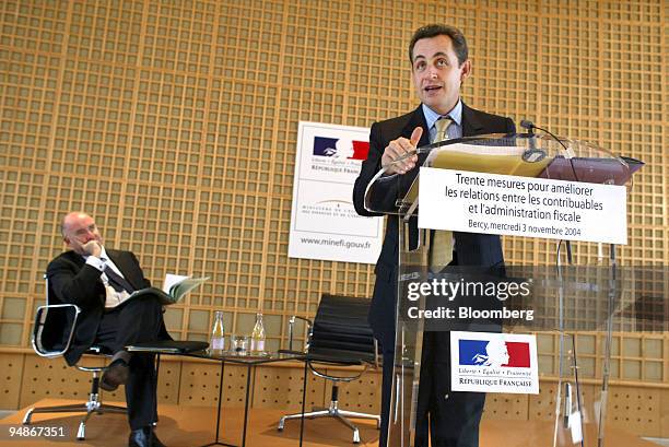 Nicolas Sarkozy, right, French State Minister of Finances and Economy, announces new fiscal measures during a press conference, watched by Dominique...