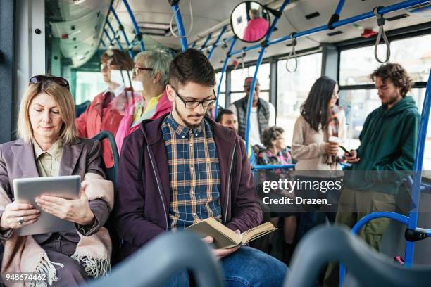 geschäftsfrau mit tablett und student lesebuch im bus - laptop on bus stock-fotos und bilder