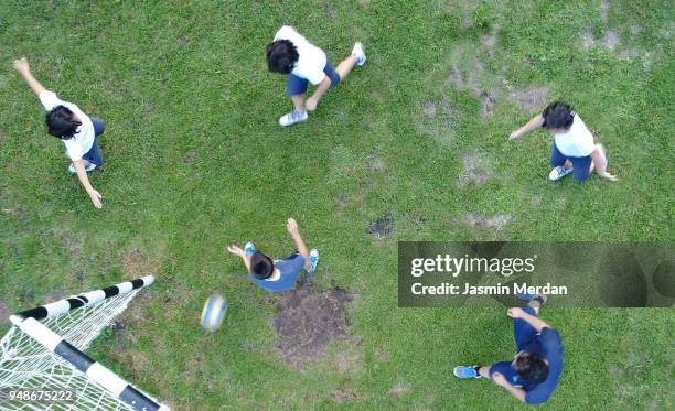 aerial view of boys playing football on field - soccer field park stock pictures, royalty-free photos & images