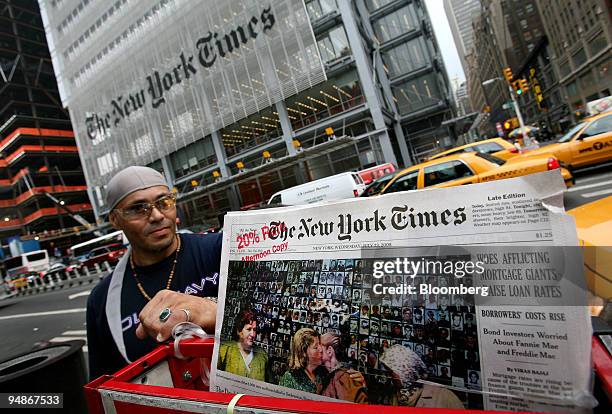Rafael Bermudes of New York, left, looks over the news rack from which he sells the New York Times newspaper in New York, U.S., on Wednesday, July...