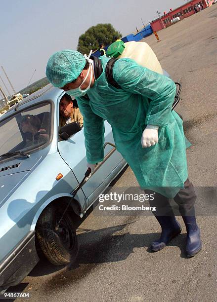 Romanian health officials spray vehicles against avian flu leaving and entering the region of Tulcea, Romania, on Tuesday, October 11, 2005. Romanian...