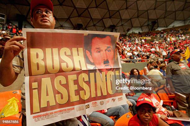 Man holds a poster depicting George Bush with a moustache like Adolph Hitler in Caracas, Venezuela, Friday, January 27, 2006. The poster reads "Bush,...
