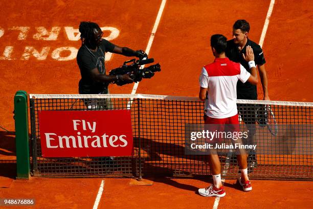 Dominic Thiem of Austria shakes hands with Novak Djokovic of Serbia after beating him in their men's singles 3rd round match on day five of the Rolex...