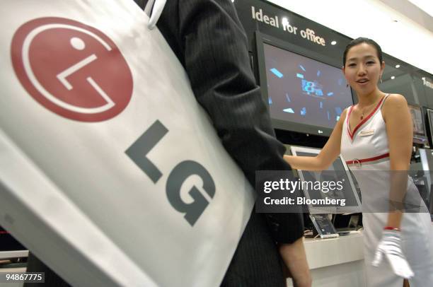 An assistant explains an LG.Philips LCD Co. Monitor's features to a visitor at the 2005 Korea Electronics Show in Ilsan, South Korea Tuesday, October...