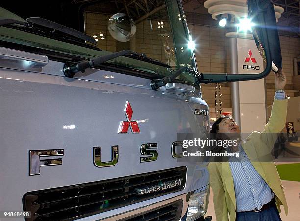 Man inspects a Mitsubishi Fuso Super Great truck at the 38th Tokyo Motor Show on Tuesday, November 2 at Makuhari, east of Tokyo. DaimlerChrysler AG,...