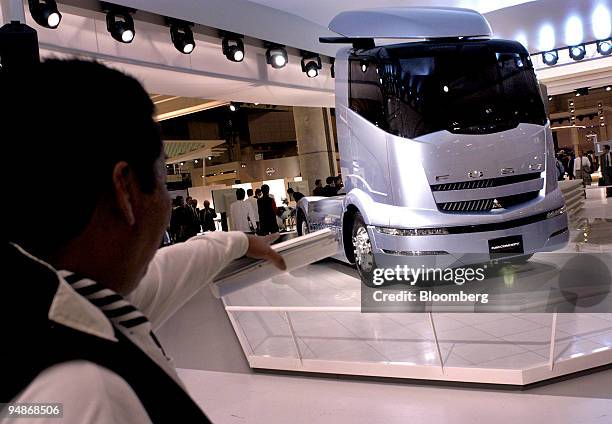 Man inspects a Mitsubishi Fuso concept truck on display at the 38th Tokyo Motor Show on Tuesday, November 2 at Makuhari, east of Tokyo. Mitsubishi...