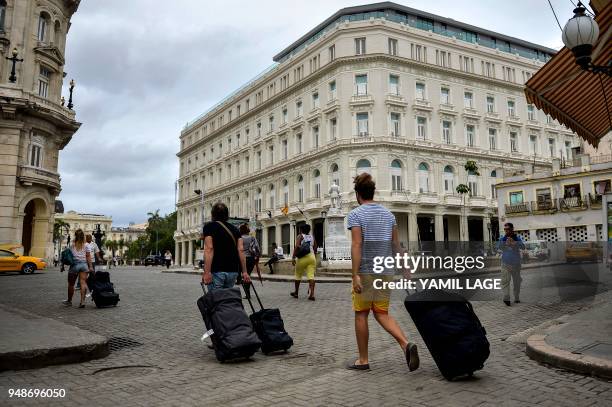 Tourists walk near the Manzana Kempinski Hotel in Havana on April 19 day in which Miguel Diaz-Canel was formally named Cuba's new president, and thus...