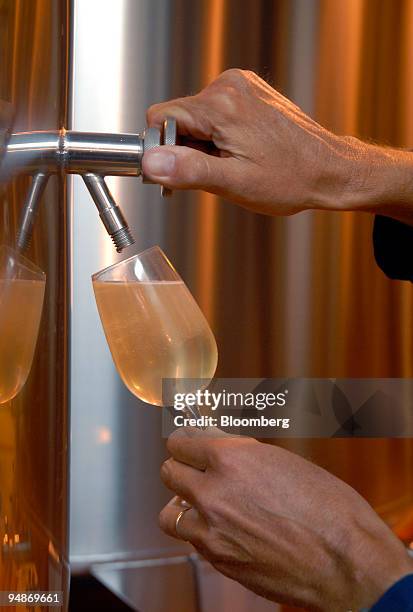 Worker takes a glass of champagne from a blending vat at the Piper-Heidsieck champagne factory, owned by Remy-Cointreau, in Reims, France, on Monday,...