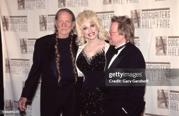 Portrait of, from left, Country musicians Willie Nelson and Dolly Parton, with Pop musician and composer Paul Williams as they attend the Songwriters...