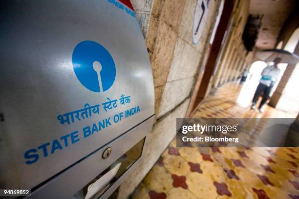 People walk past the State Bank of India main branch office in Mumbai, India, on Monday, July 28, 2008. State Bank of India reported the slowest...
