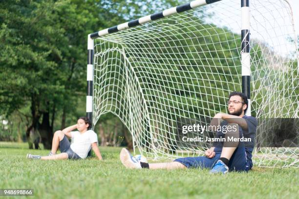 resting on goal after soccer game - kicking tire stock pictures, royalty-free photos & images