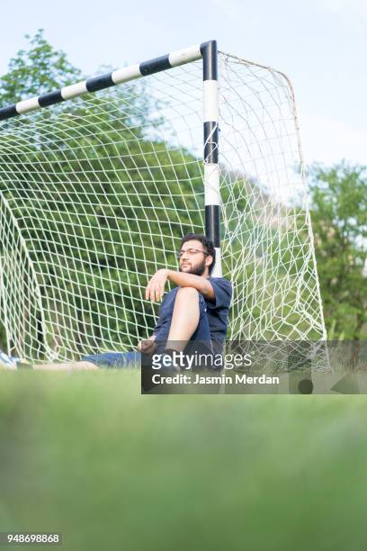 resting on goal after soccer game - kicking tire stock pictures, royalty-free photos & images