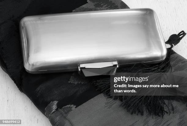 a silver clutch over a black shawl. still life. - black tie party fancy stock pictures, royalty-free photos & images