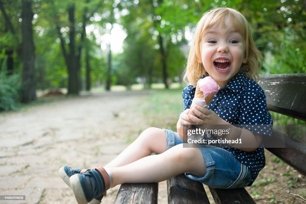 Little child eating ice cream in a park