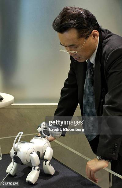 Businessman looks at an 'Aibo' robotic dog manufactured by Sony Corp. In a Tokyo shop Thursday, October 28, 2004. Sony Corp., the world's...