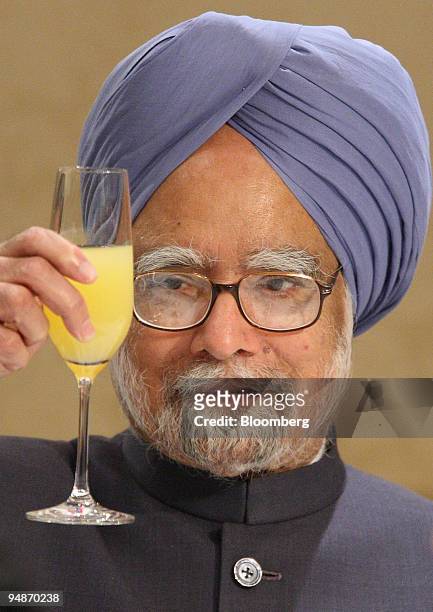 Manmohan Singh, India's Prime Minister, holds a glass before toasting with Japan's business leaders during a welcome luncheon hosted by the Nippon...