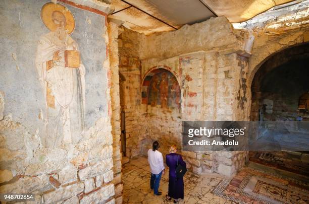 People inspect ancient drawings at Santa Claus Church on the route of Lycian Way in Demre district of Mugla, Turkey on April 12, 2018. Lycian way is...