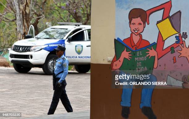 Military police officer stands guard outside a school in Tegucigalpa, on April 18, 2018. - Students are also victims of the prevailing insecurity in...