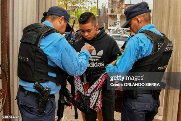 Police officers search a student's backpack in Tegucigalpa, on April 18, 2018. - Students are also victims of the prevailing insecurity in Honduras,...