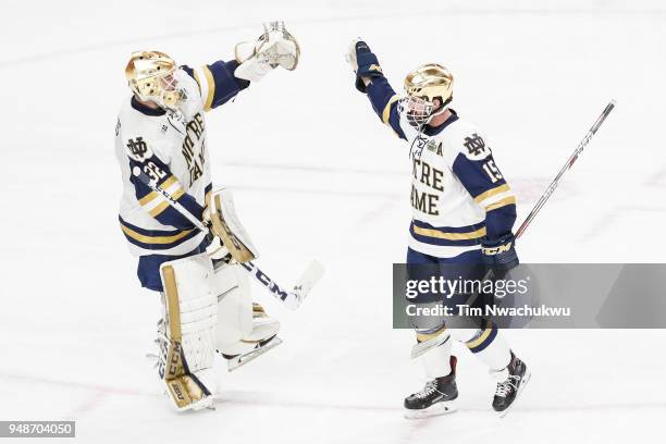 Cale Morris of the Notre Dame Fighting Irish high fives teammate Andrew Oglevie after Oglevie scored against the Minnesota-Duluth Bulldogs during the...