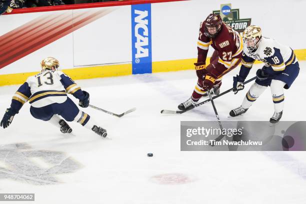 Riley Tufte of the Minnesota-Duluth Bulldogs and Jake Evans of the Notre Dame Fighting Irish, both right, chase a loose puck during the Division I...