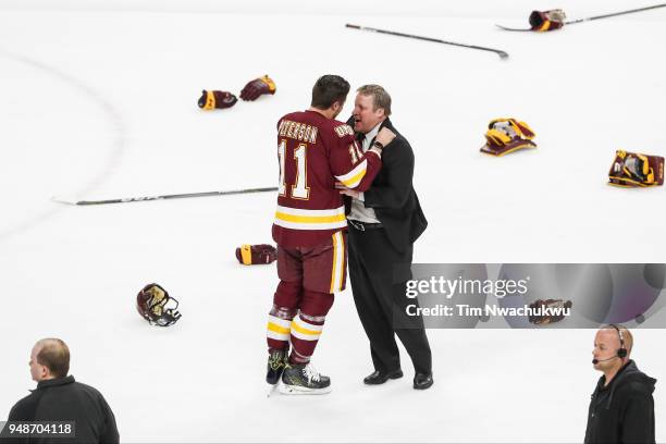 Avery Peterson of the Minnesota-Duluth Bulldogs embraces Minnesota-Duluth head coach Scott Sandelin during the Division I Men's Ice Hockey...