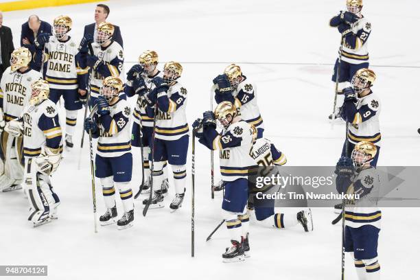 Members of the Notre Dame Fighting Irish watch as the University of Minnesota Duluth Bulldogs celebrates during the Division I Men's Ice Hockey...